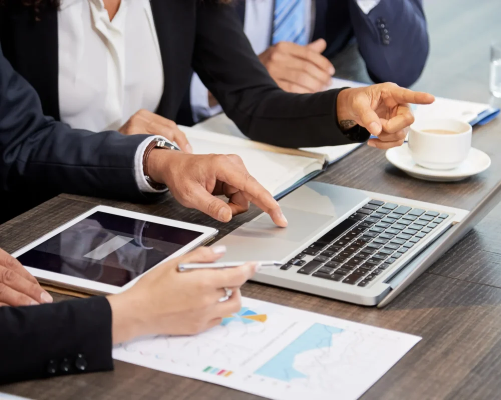 crop-colleagues-using-laptop-table